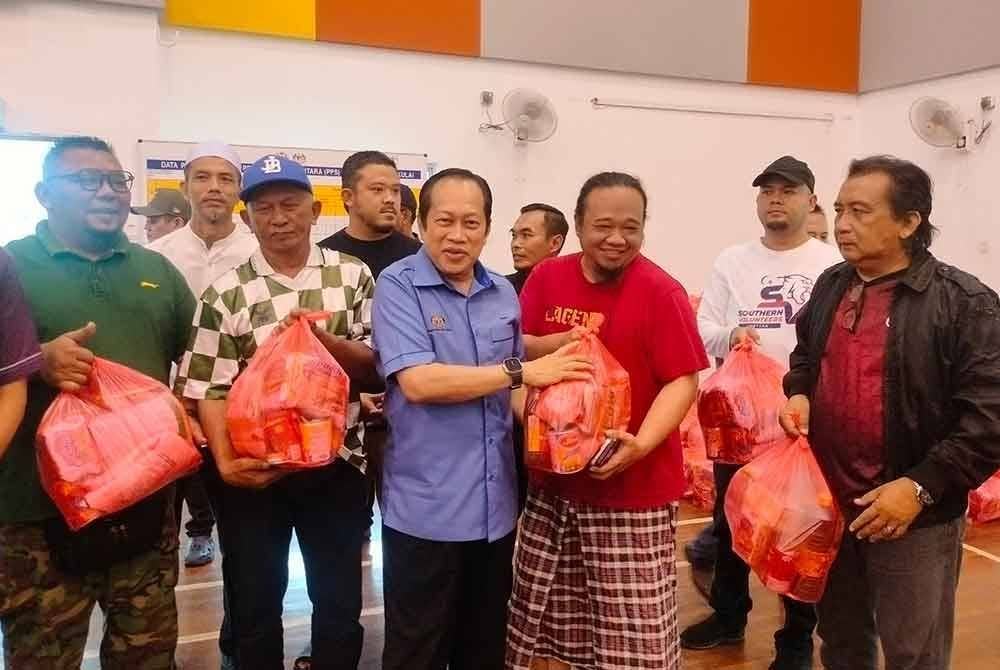 Ahmad (dua kanan) menyerahkan sumbangan kepada mangsa banjir di PPS SMK Bukit Batu, Kulai pada Ahad.