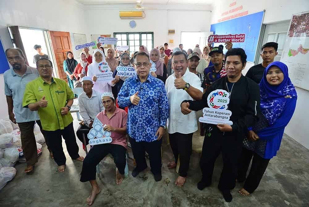 Abdul Fattah (depan, empat dari kanan) bergambar bersama penerima bantuan pada majlis 'Projek kotak Syawal' anjuran Kelab Sukan Kebajikan Sosial dan Edukasi Sungai Buloh (Sukses) dan Angkasa pada Ahad.