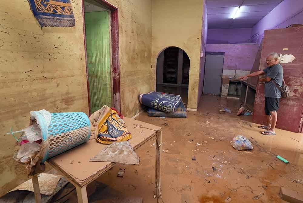 Mangsa banjir Arip Aripin, 78, melihat keadaan rumah yang kotor dan berlumpur akibat banjir besar yang melanda Johor 19 Mac lalu, ketika tinjauan di Kampung Pasir Tebrau hari ini.
