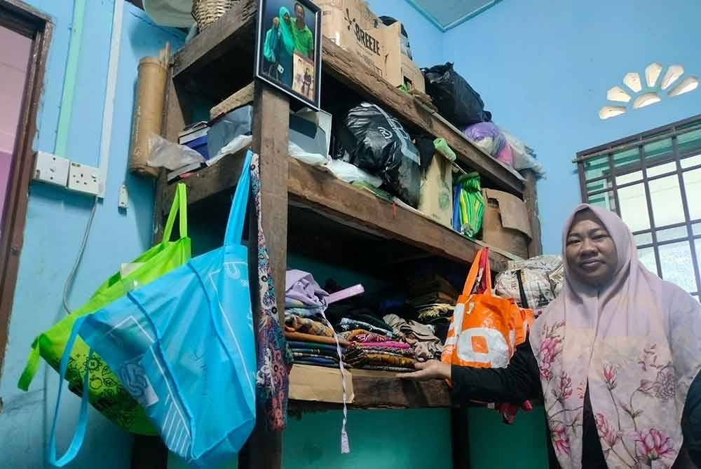 Nor Hamizah menunjukkan paras air ketika rumahnya ditenggelami banjir.