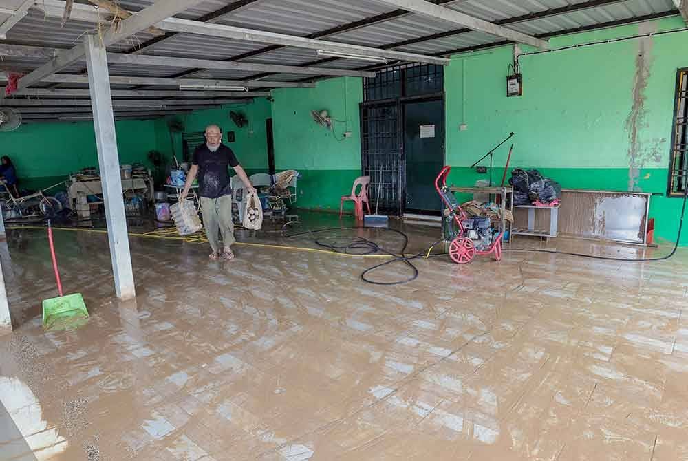 Seorang petugas Surau Al-Hijrah giat melakukan pembersihan surau yang ditenggelami banjir besar pada 19 Mac lalu ketika tinjauan di Kampung Pasir Tebrau hari ini. - Foto: Bernama