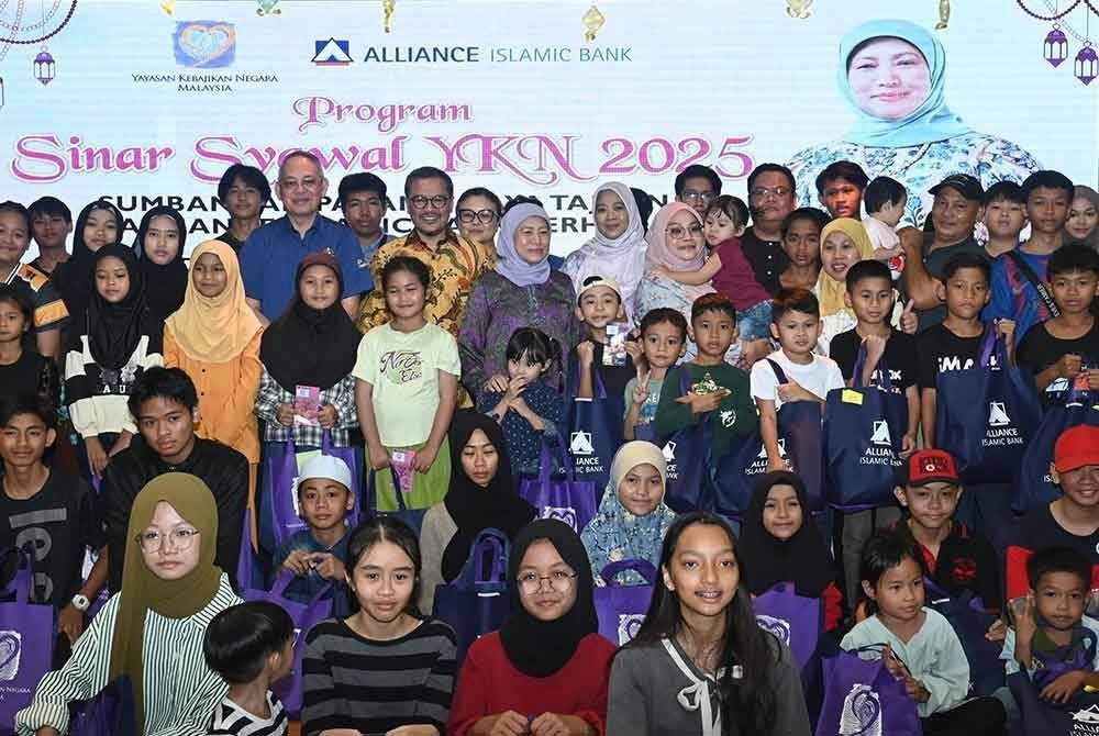 Nancy Shukri (tengah bertudung biru) bergambar bersama 200 penerima sumbangan Program Sinar Syawal YKN 2025 serta wakil Alliance Islamic Bank Berhad di Mydin Vista Tunku, Kuching.