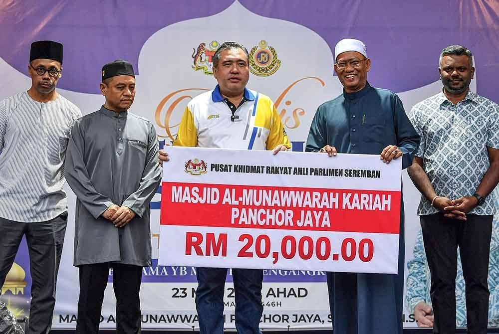 Anthony Loke (tiga dari kiri) menyampaikan replika cek kepada Pengerusi Masjid Al-Munawwarah Kariah Panchor Jaya, Azmi Mohd Yusoff (dua dari kanan) pada Majlis Berbuka Puasa Santuni Madani di Masjid Al-Munawwarah, hari ini. - Foto: Bernama