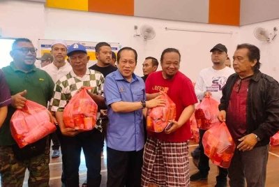 Ahmad (dua kanan) menyerahkan sumbangan kepada mangsa banjir di PPS SMK Bukit Batu, Kulai pada Ahad.