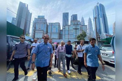Tun M (tengah) meninjau kawasan Kampung Sungai Baru yang terlibat dengan projek pembangunan semula pada Ahad.