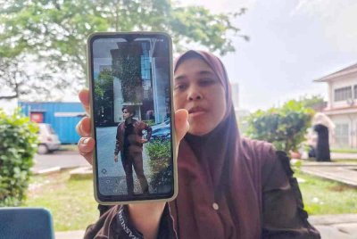 Jamilah menunjukkan gambar kenangan anaknya, Muhammad Syabil Hakimi.