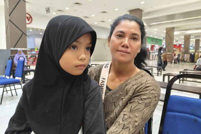 Liza memangku anak saudaranya,Aleyana Fathia yang kehilangan ibu bapa pada 2018.