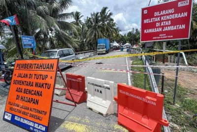 Keadaan jambatan di Kampung Felda Air Tawar 1 yang runtuh akibat banjir kilat yang melanda awal pagi tadi pada tinjauan hari ini. - Foto: Bernama