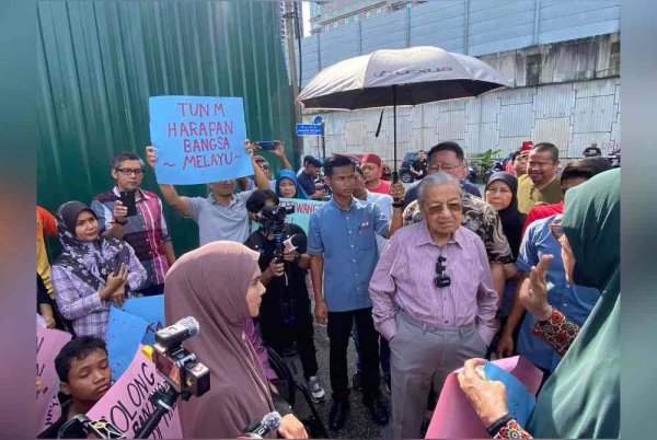 Tun M (dua dari kanan) berinteraksi dengan penduduk asal Kampung Sungai Baru termasuk Rafidah (kiri), ketika tinjauan pada Ahad.