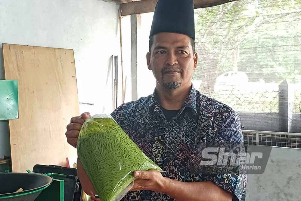 Ramlee menunjukkan cendol yang dihasilkannya di Kampung Padang pada Isnin.