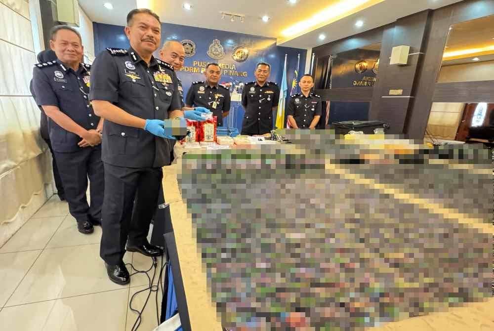 Hamzah (kiri) menunjukkan dadah yang dirampas pada sidang akhbar di Ibu Pejabat Polis Kontinjen Pulau Pinang pada Isnin.