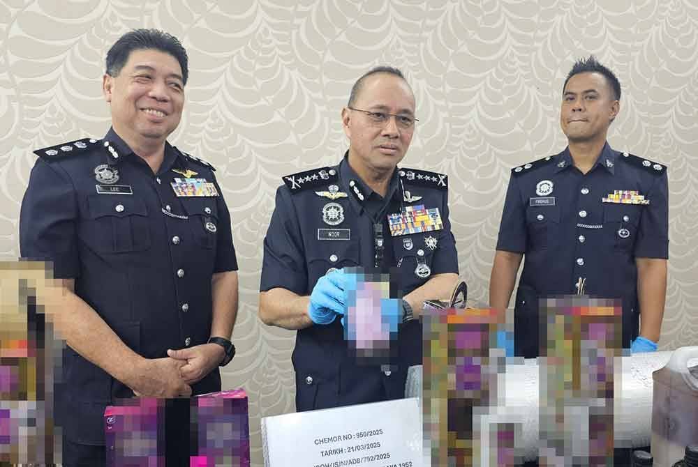 Noor Hisam (tengah) menunjukkan cecair dadah bernilai lebih RM1.19 juta yang berjaya dirampas daripada pasangan suami isteri di Ipoh.