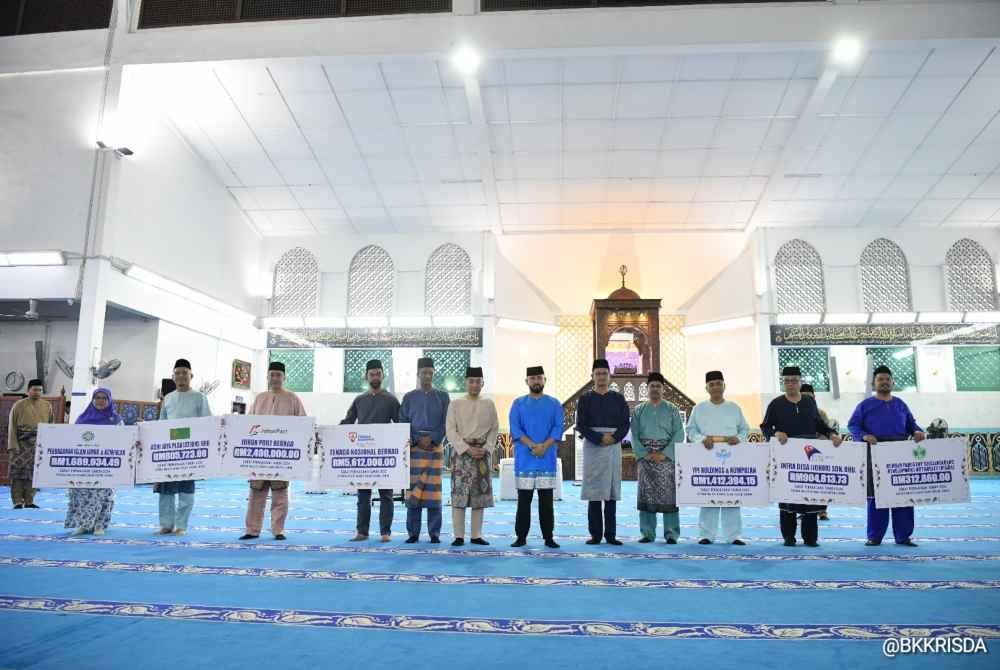 Tunku Mahkota Ismail (tujuh dari kiri) bergambar bersama penyumbang zakat lain.