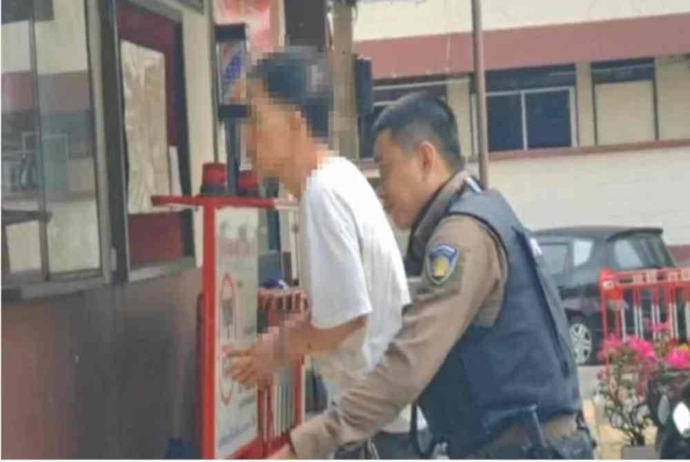 Suspek dibawa polis selepas menambak abang ipar selepas pertikaian harta di Bang Mod, Chom Thong, Bangkok. Foto Agensi
