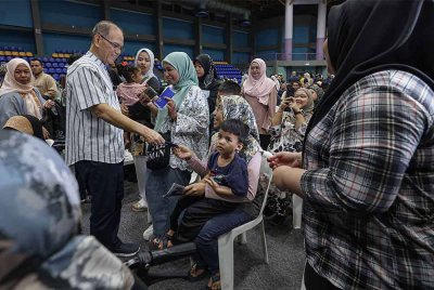 Wan Rosdy beramah mesra sambil menyampaikan sumbangan kepada pengunjung yang terdiri daripada anak jati Pahang pada Majlis Penyerahan Baucar Moh Balik Raya Ke Pahang 2025 di Stadium Titiwangsa hari ini. - Foto: Bernama