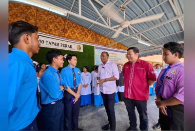 Saravanan (tiga dari kanan) menyantuni pelajar dari Sekolah Menengah Kebangsaan (SMK) Sri Tapah sempena program penyerahan sumbangan Aidilfitri kepada sekolah-sekolah menengah dalam Parlimen Tapah pada Isnin.