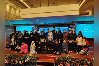 Nurul Amal (berdiri, tengah) bersama penerima yang juga merupakan anak-anak yatim dan kurang bernasib baik.