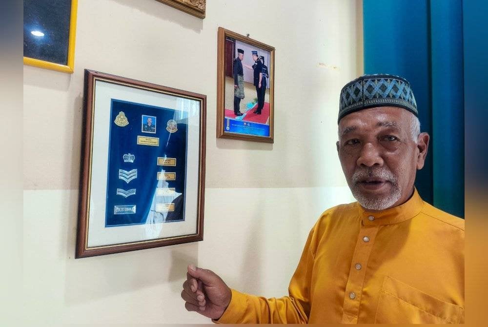 Muhamad Puzi menunjukkan pangkat-pangkat yang diperolehinya semasa berkhidmat bersama polis selama 40 tahun.