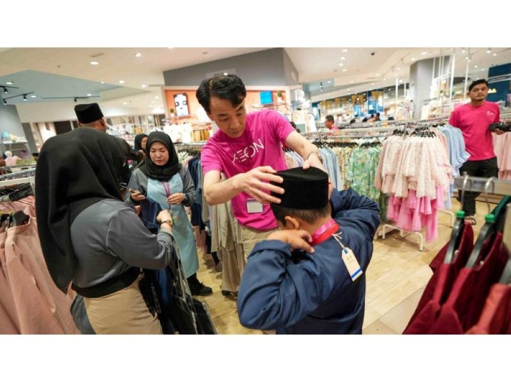 Timbalan Pengarah Urusan AEON, Tsugutushi Seko membantu kanak-kanak mendapatkan pakaian raya mereka.