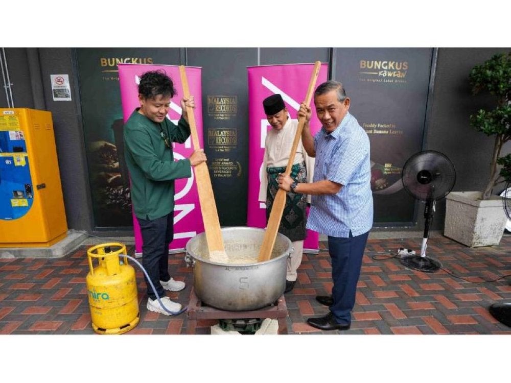 Aminuddin (kanan), Iskandar (tengah) dan Naoya (kiri) turut sama dalam aktiviti memasak bubur lambuk.