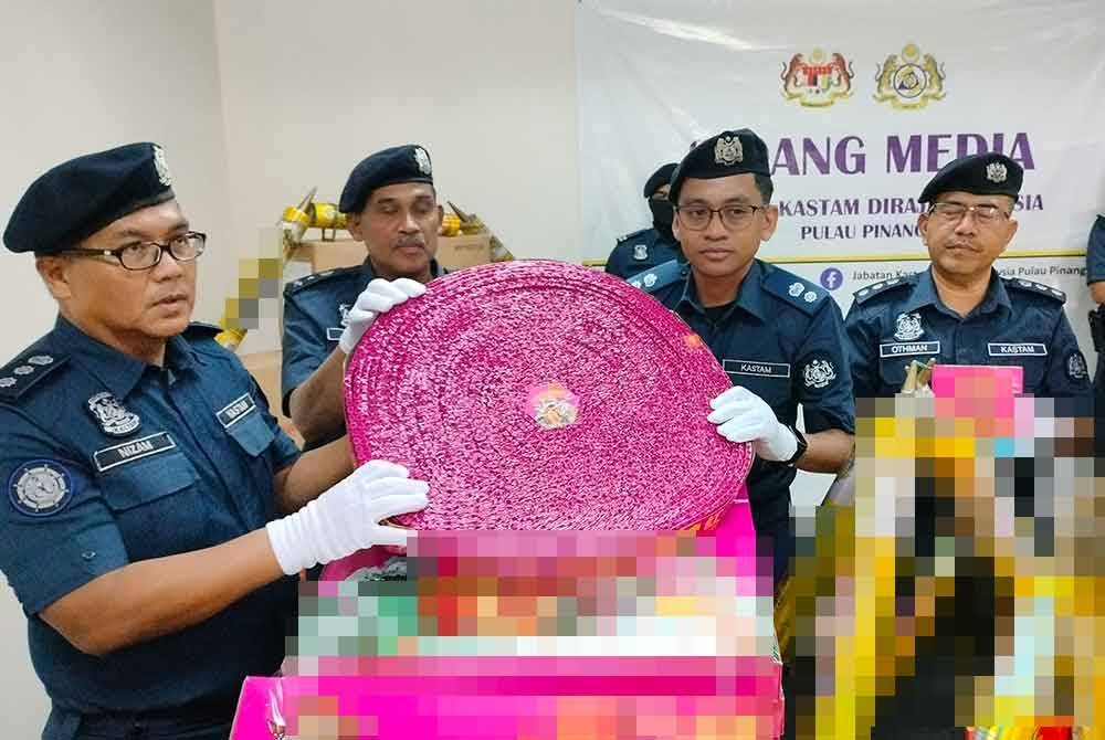 Pegawai Kastam menunjukkan sebahagian mercun dan bunga api yang dirampas.