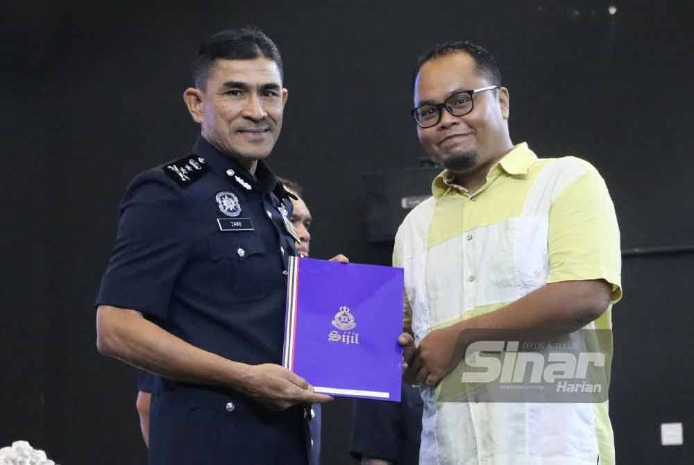 Mohd Zaini (kiri) menyampaikan sijil penghargaan kepada Muhammad Aminnuraliff sempena Hari Peringatan Polis ke-218 di IPK Selangor pada Selasa.