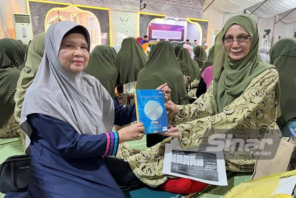 Surena (kiri) menyampaikan cenderehati iaitu al-Quran kepada Wan Shamila (kanan).