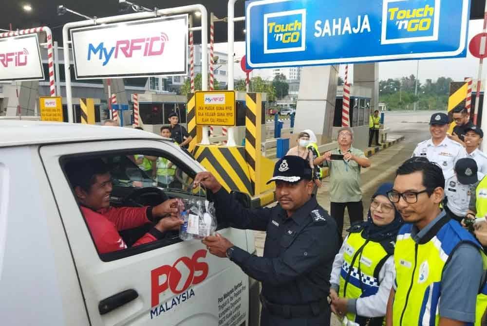 Hussein mengedarkan pek makanan kepada pengguna Lebuhraya Kajang-Seremban di Kajang, pada Selasa.