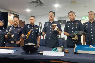 Christopher (empat dari kiri) menunjukkan sebahagian barang yang berjaya dirampas dalam serbuan berasingan itu.