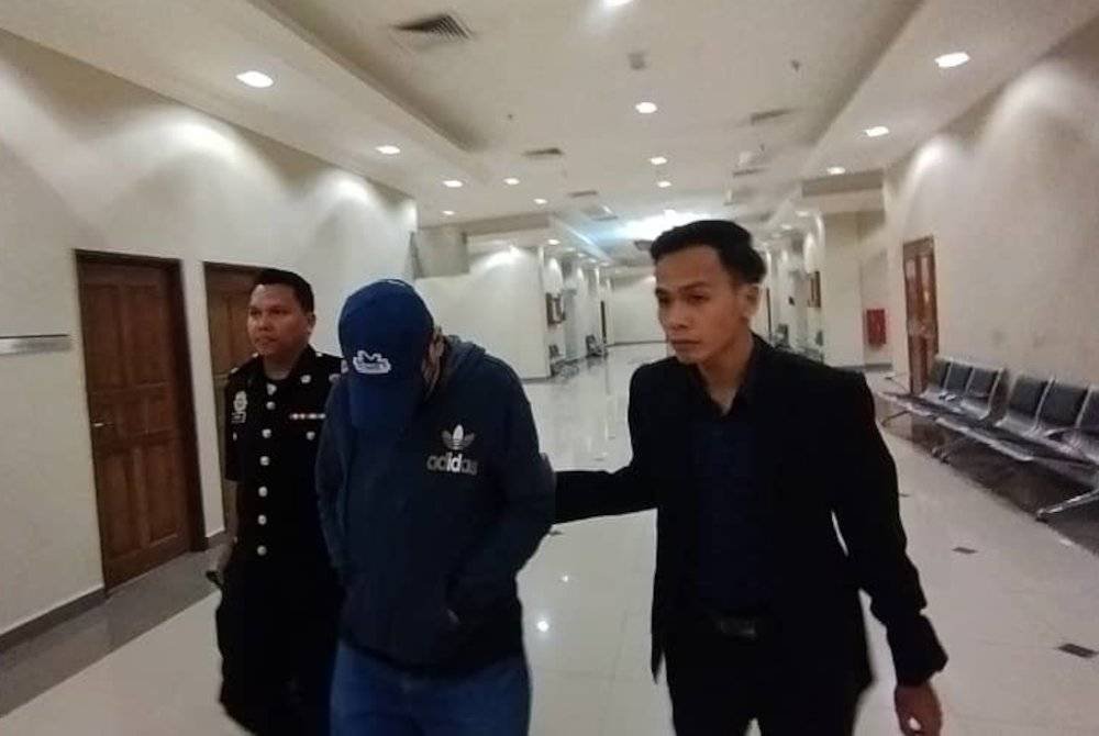 Tertuduh (tengah) diiringi pegawai SPRM keluar dari mahkamah selepas mengaku bersalah dan dijatuhkan hukuman atas dua tuduhan rasuah, dua tahun lalu.