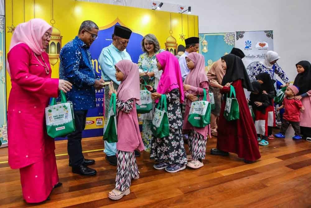Penerima menerima sumbangan keperluan asas, makanan dan duit raya pada Majlis Amal Iftar Perdana Persatuan Sinaran Hidup yang berlangsung di PPR Hiliran Ampang, malam tadi.