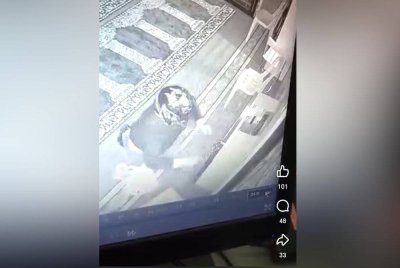 Tangkap layar video tular menunjukkan seorang lelaki memecah tabung surau di Kampung Mambau pada Sabtu lalu.