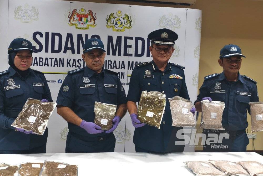 Muhammad Ilyas (dua dari kanan) menunjukkan tembakau kunyah yang disita.