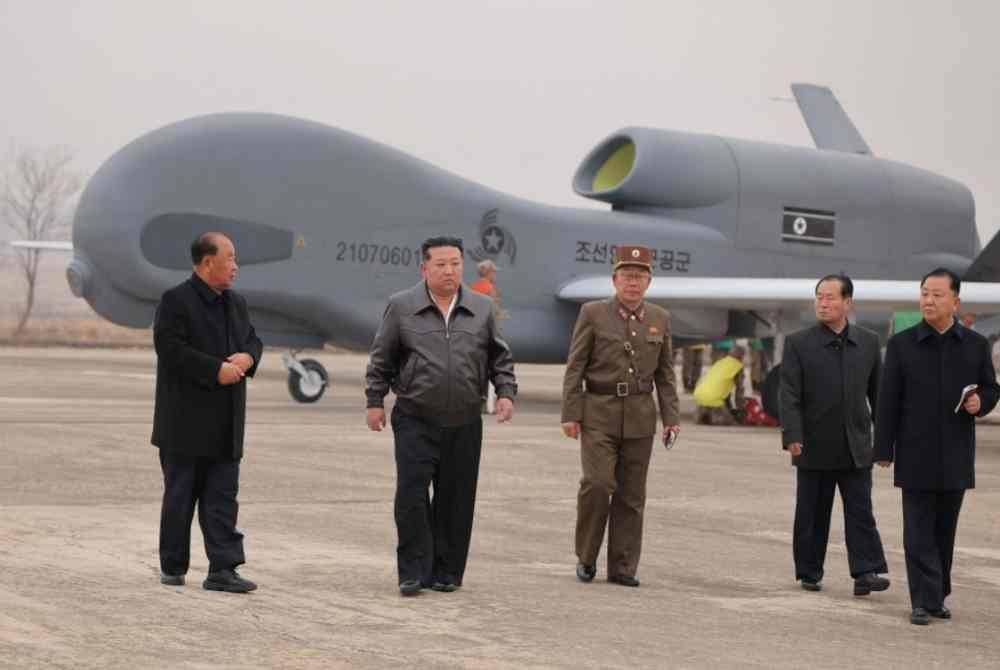 Kim Jong Un (dua dari kiri) sedang memeriksa pesawat pengintipan tanpa pemandu yang baru dibangunkan di lokasi yang tidak didedahkan di Korea Utara. Foto AFP
