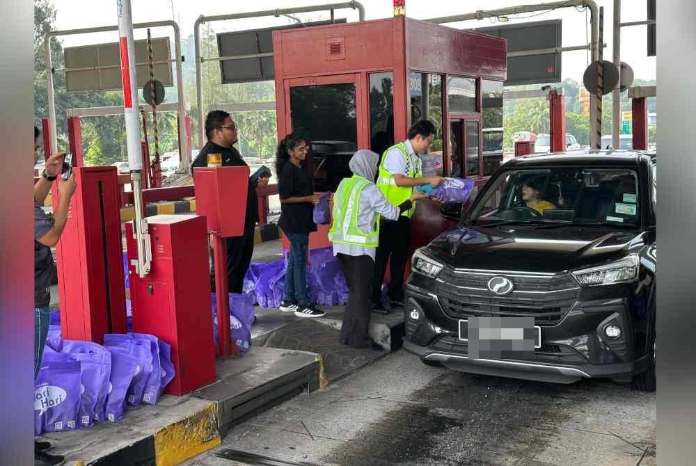 Pusat Pakaian Hari-Hari mengagihkan beg 'goodies' berisi kurma, air mineral, tuala, baucar dan duit raya RM5 x 500 set kepada pengguna lebuh raya Plaza Tol Batu 11, Cheras.