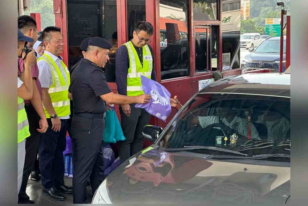 Agihan beg 'goodies' oleh anggota polis dari Ibu Pejabat Polis Daerah (IPD) Kajang kepada pengguna lebuh raya.