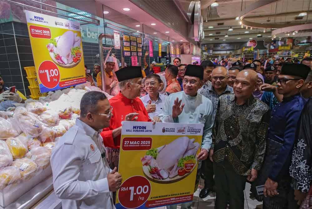 Perdana Menteri, Datuk Seri Anwar Ibrahim menunjukkan tanda harga ayam ketika hadir pada kempen turun harga dan perletakan logo Singgah Madani di Mydin USJ pada Khamis. Foto Bernama