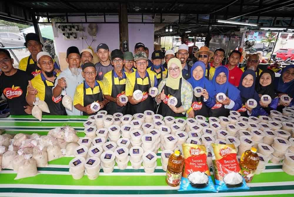 Noor Azreena (enam dari kanan) bersama penduduk sekitar yang menyediakan bubur lambuk di Masjid An-Naim, Jalan Kebun, Shah Alam.