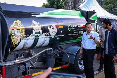 Nik Nazmi (kiri) berbual bersama Vinesh Sinha (kanan) semasa menghadiri Program Fathopes Energy bersama EkoSetiawangsa untuk mengedarkan tong minyak kepada peniaga bazar bagi mengisi minyak masak terpakai di Bazar Ramadan Setiawangsa, hari ini. - Foto: Bernama