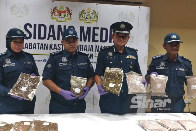 Muhammad Ilyas (dua dari kanan) menunjukkan tembakau kunyah yang disita.