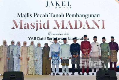 Mohamed Faroz (lapan dari kiri) dan seluruh ahli keluarga bergambar bersama Anwar semasa Majlis Pecah Tanah Pembangunan Masjid Madani, Kuala Lumpur pada Khamis.