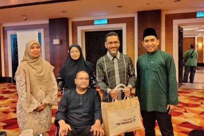Wan Mohd Firdaus (duduk) dan Ahmad Shazly (dua dari kanan) ketika Program Memacu Kehidupan: Hari Raya Aidilfitri Yayasan Petronas pada Rabu.