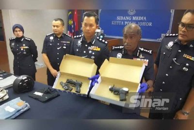 Kumar (dua, kanan) menunjukkan tiga pucuk pistol yang dirampas pada sidang akhbar di IPK Johor pada Khamis.