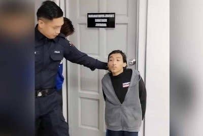 Mohamad Hafiz (kanan) diiringi polis di mahkamah pada Khamis.