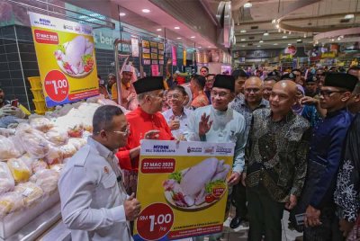 Perdana Menteri, Datuk Seri Anwar Ibrahim menunjukkan tanda harga ayam ketika hadir pada kempen turun harga dan perletakan logo Singgah Madani di Mydin USJ pada Khamis. Foto Bernama