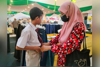Zuraini sedang memilih seluar untuk anaknya, Muhammad Zabidin yang ditaja sebuah pasar raya, Central Square Sungai Petani.