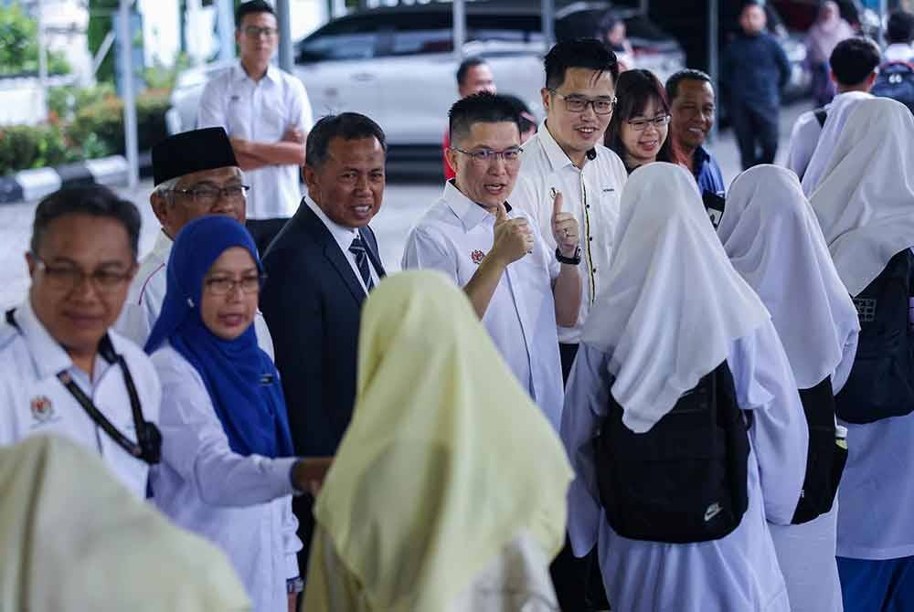 Timbalan Menteri Pendidikan, Wong Kah Woh (tengah) menyantuni calon-calon peperiksaan ketika hadir meninjau hari pertama peperiksaan bertulis SPM 2024 di Sekolah Menengah Kebangsaan Kampong Pasir Puteh Ipoh.