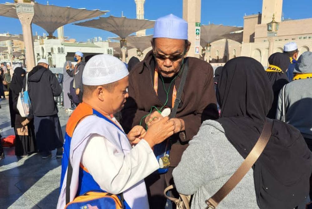 AZIZAM (kiri) berpengalaman membawa kira-kira 1,500 jemaah ke Tanah Suci Makkah dan Madinah sejak 15 tahun lalu.