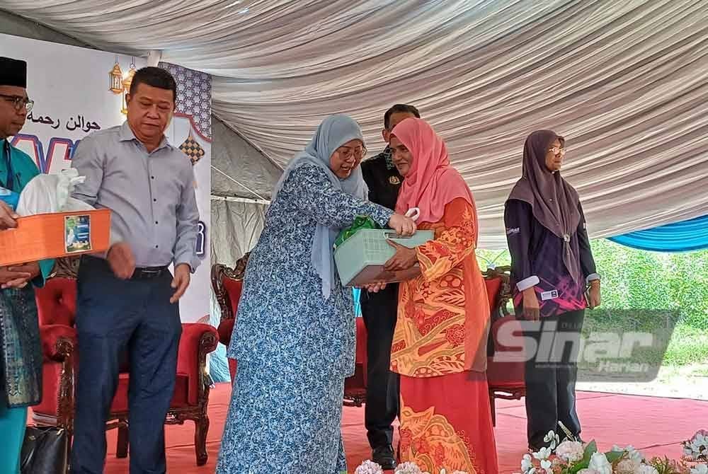 Fuziah (tengah) menyampaikan bakul makanan kepada penerima selepas tinjauan mesra pada program jualan Rahmah Madani mega Aidilfitri di hadapan pasar nelayan Pantai Sepat pada Jumaat. - Foto Sinar Harian