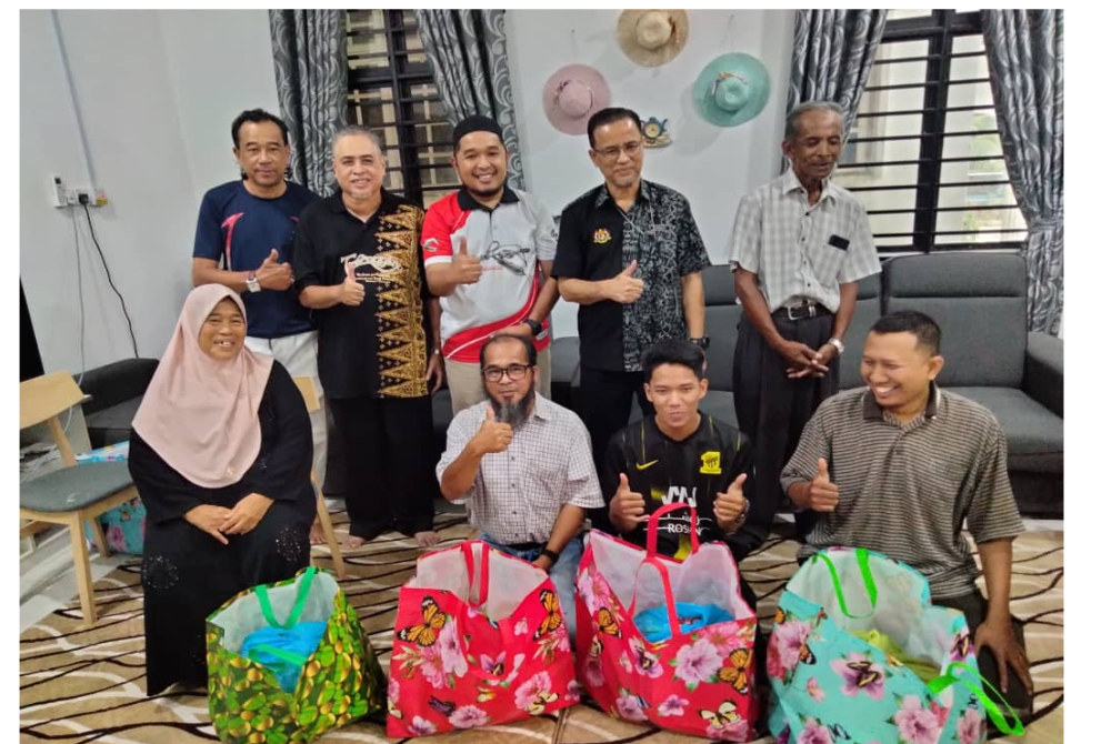 Azaman (berdiri, dua dari kanan) bersama bekas pengamal media Kelantan termasuk Ismail (berdiri, dua dari kiri) selepas menyampaikan sumbangan kepada mereka.